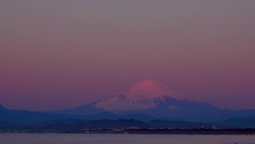 Mount fuji at sunset with a pink glow over the snowcapped peak