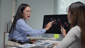 Professional businesswomen collaborating while analyzing financial charts on computer screen, discussing investment strategy and market trends in modern office environment - Powered by Shutterstock - Get 15% off with code: PIKWIZARD15