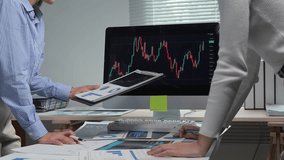 Business colleagues analyze stock market data on a computer screen, discussing potential investment strategies - Powered by Shutterstock - Get 15% off with code: PIKWIZARD15