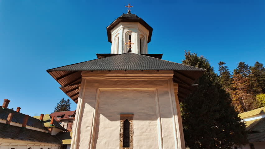 Exterior of the Sinaia Orthodox Monastery, Sinaia, Transylvania, Romania, shows stone walls, arched windows, and a compact courtyard, conveying the monastic ensemble and its calm proportions
