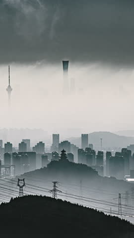 Aerial footage of Beijing, China, showing industrial networks, mountains, and city buildings shrouded in clouds and mist