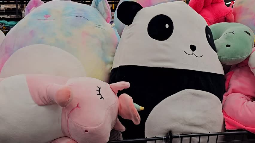 Collection of large plush toys including a panda, unicorn, and dinosaur in various colors. The toys are soft and oversized, ideal for children.