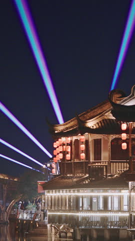 Zhujiajiao, Shanghai, China. traditional architecture illuminated with festive lights during the night, enhancing the lively atmosphere around the waterways and buildings.