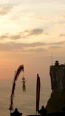 Sunset over Uluwatu Temple and Ocean Cliff Bali island Indonesia Southeast Asia. Vertical shot.