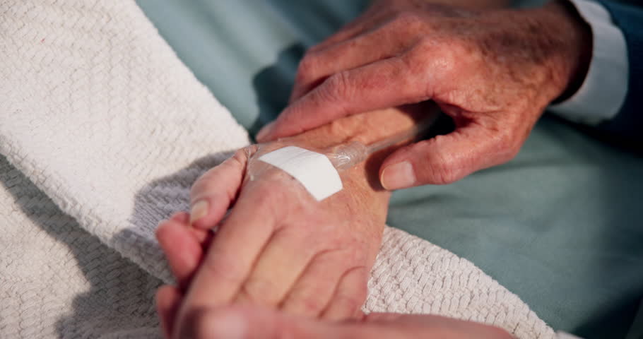 Couple, holding hands and comfort patient on hospital bed for support, empathy and post surgery. Closeup, old people and sick partner with iv drip for recovery, operation sympathy and healing in icu