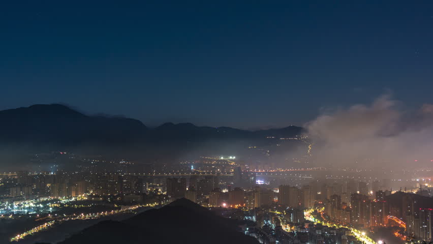 A night view of Beijing, a city surrounded by mountains, with drifting clouds and mist
