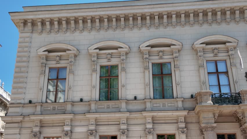 Pan across the historic exterior of Andrássy University in Budapest, highlighting its ornate neoclassical design and architectural details