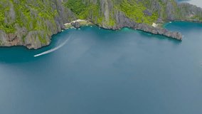 Boats and white sand beach in Secret Lagoon and Jijis Beach. Top view of tropical island surrounded by blue sea. El Nido, Philippines. - Powered by Shutterstock - Get 15% off with code: PIKWIZARD15
