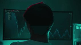 Angry stock trader male gesturing obscenely toward volatile stock market chart on dimly lit computer screen, revealing financial stress during late-night trading session. Concept of financial crisis. - Powered by Shutterstock - Get 15% off with code: PIKWIZARD15