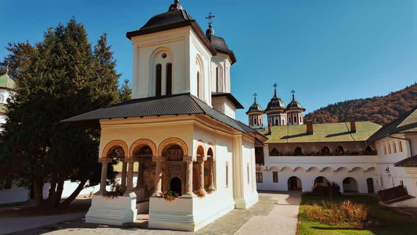 Exterior of the Sinaia Orthodox Monastery, Sinaia, Transylvania, Romania, shows stone walls, arched windows, and a compact courtyard, conveying the monastic ensemble and its calm proportions
