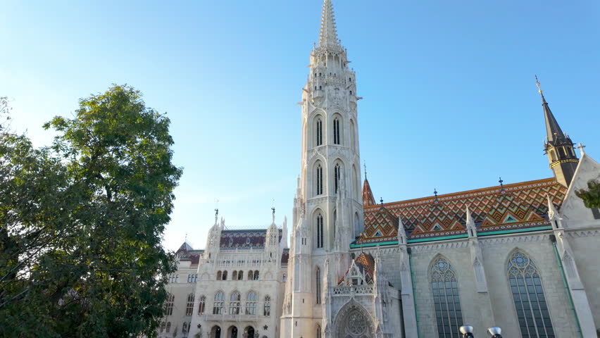 Stunning Matthias Church Gothic Architecture with Colorful Zsolnay Roof Tiles in Budapest - Historic Roman Catholic Church Showcasing Medieval Spires and Ornate Details Against Vibrant Blue Sky