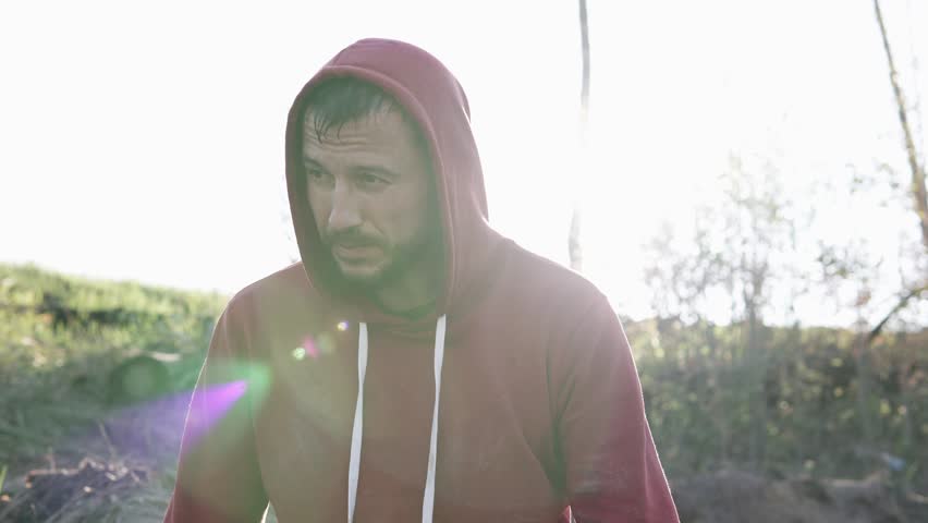 A man stands in warm sunlight, quietly reflecting on his life and uncertain future.