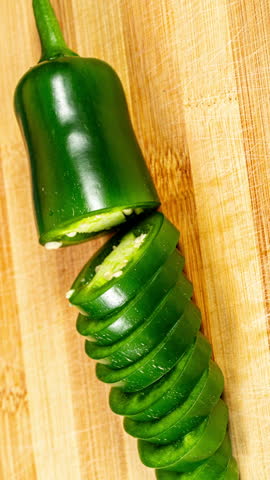 Chopping Green Jalapeno Pepper. Closeup of Sliced Vegetable on Wooden Cutting Board. Stop Motion Animation