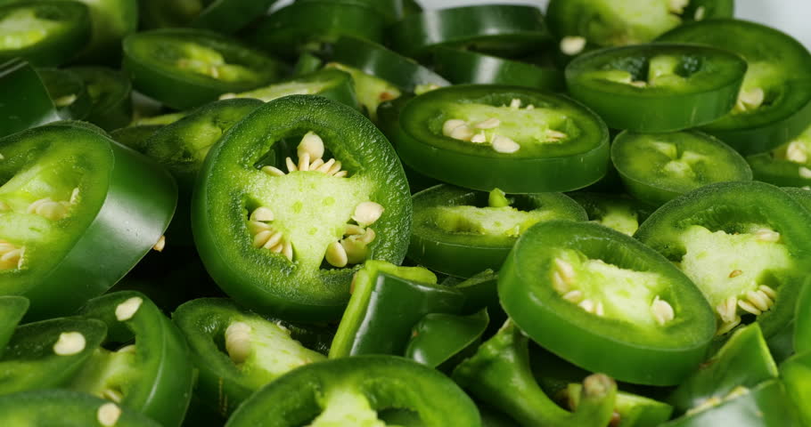 Green Jalapeno Chili Peppers Slices Food Rotate Footage. Close Up Background of Green Plants