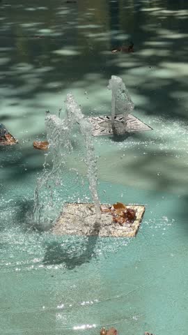 Small fountain with water splashing from the ground. Vertical. Dry Fountain