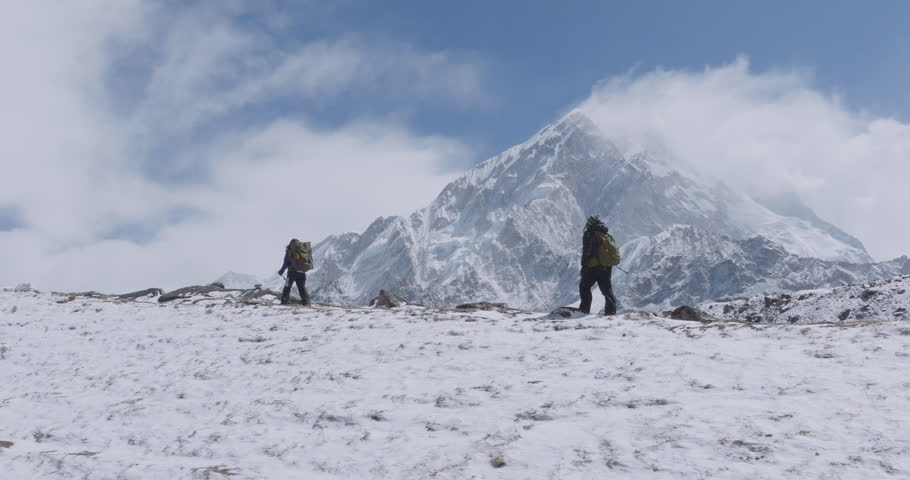 Drone shot of tourists hiking enroute to Everest Base Camp trek taking photos in Khumbu, Nepal. Morning light and reveal snow-capped Himalayan peaks, breathtaking scenery, heavenly travel experiences