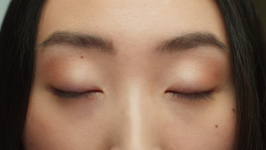Cropped view Korean black female eyes looking at camera close up eyebrows make-up natural cosmetic gaze Asian woman look happy charming Chinese Korean girl long lashes good eyesight vision medicine