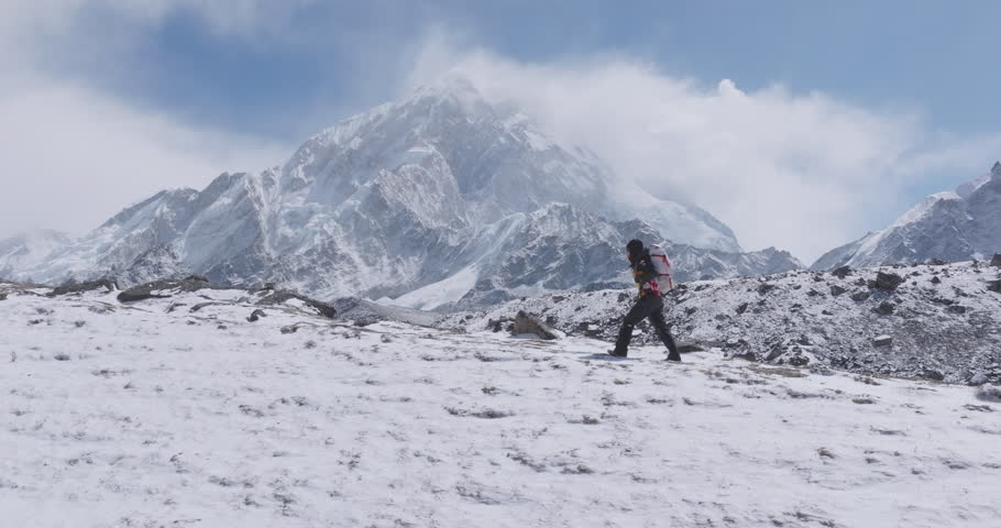 Drone shot of tourist hiking to Everest Base Camp trek in Khumbu, Nepal, carrying a rucksack and essentials. Morning light reveals snow-capped Himalayan peaks, breathtaking scenery heavenly adventure