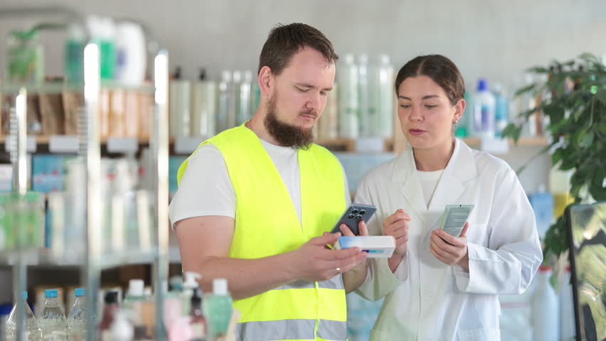 Male producer scans a package of cooling ointment for muscles and joints on a mobile barcode. Woman pharmacist helps a man make a payment using a qr code at a pharmacy. High quality 4k footage