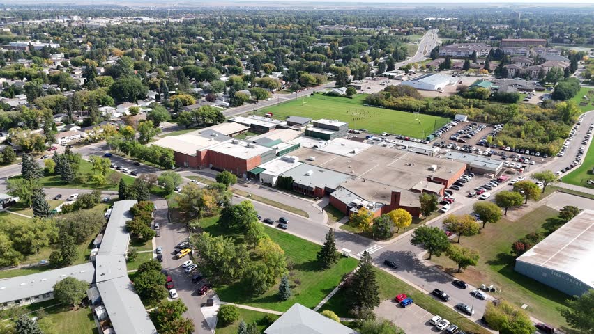 4K aerial view of Nutana Suburban Centre in Saskatoon, showing condos, retail, seniors’ housing, schools, and parks in this central east side neighborhood.