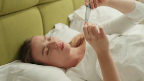 Caucasian woman measuring temperature sneezing holding head headache pain bad feeling medicine health trouble virus pandemic covid 19 ill girl sick female lying in bed fever sneeze coronavirus symptom - Powered by Shutterstock - Get 15% off with code: PIKWIZARD15