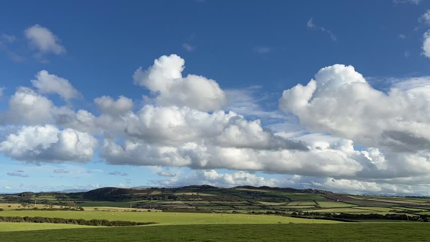 Time-Lapse of clouds moving over a rural landscape at sunrise near Llanerchymedd on the Isle of Anglesey in Gwynedd off the north Wales coast.