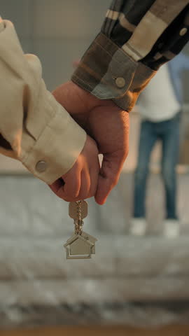 Close up arms couple hands holding keys of new tenant rent home son boy jumping having fun joy African American parents woman man in own house family relocation credit loan mortgage insurance adopt