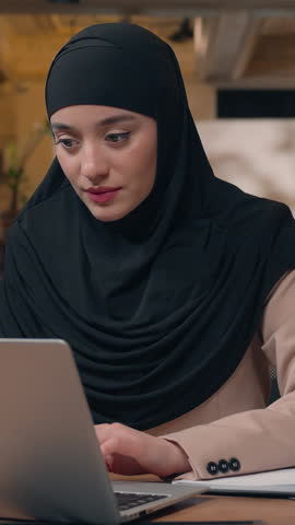 Arabian businesswoman muslim business woman with laptop papers work smiling looking at camera happy joyful islamic female girl in hijab worker with documents and computer enjoying working process