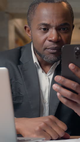 African American business man businessman winning with mobile phone web prize virtual casino bet success ethnic middle-aged adult entrepreneur executive in office male win money good offer message