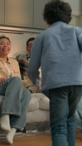 African American family at new home active son running to parents relocation funny little boy child playing with mom dad moving day happy cuddling kid mother father custody adopt insurance on sofa 