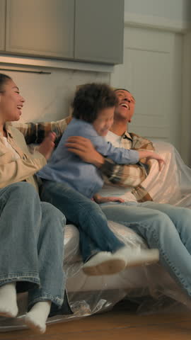 African American family at new home active son running to parents relocation funny little boy child playing with mom dad moving day happy cuddling kid mother father custody adopt insurance on sofa 