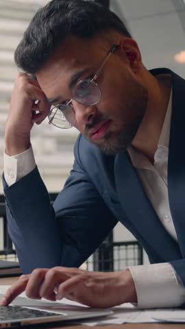 Arabian businessman Indian melancholy frustrated business man typing laptop in office stressed male guy Hispanic executive sleepy agent with computer boring work laziness trouble chronic depression