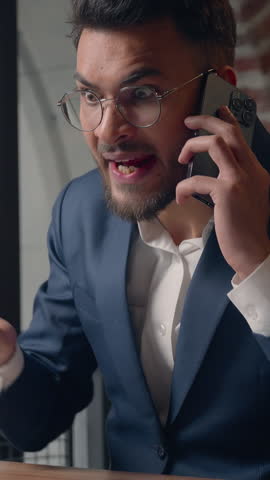 Stressed mad furious Arabian businessman arguing smartphone call business man screaming talking aggressive mobile phone in office angry Indian guy male Hindu executive annoyed job quarrel conversation