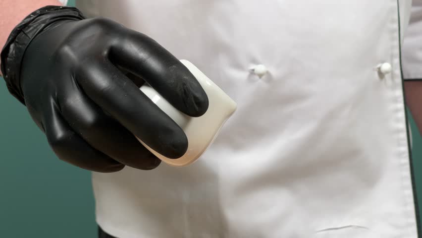 The chef pours oil onto a dish