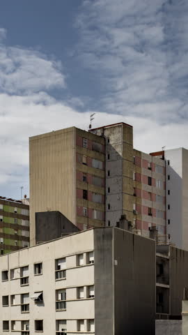 social housing apartment blocks in barcelona with passing clouds in vertical