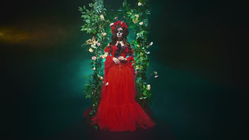 gothic beauty woman sugar skull make-up art paint white face, hand holding black rose flower. red crown on head. Fantasy goddess sexy Girl Calavera, day of the dead. dark night garden green trees arch