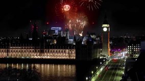Elevated view of the Big Ben clocktower, Westminster Palace and Bridge in London, England, during night time with fireworks behind - Powered by Shutterstock - Get 15% off with code: PIKWIZARD15
