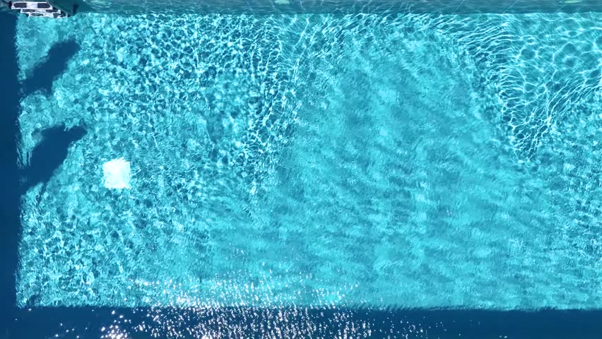 Aerial top down slow motion view of a holiday couple diving into the swimming pool, background of a summer concept