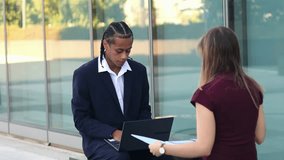 Multiethnic business partners collaborating in financial district, reviewing documents and strategizing on laptop while working together in urban professional environment - Powered by Shutterstock - Get 15% off with code: PIKWIZARD15