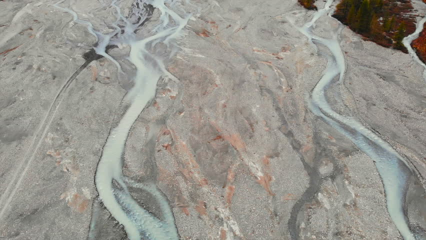 Braided river flowing through barren landscape. Media