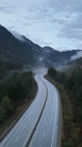Driving Through Majestic Mountain Highways Amidst Misty Forests in British Columbia, Canada