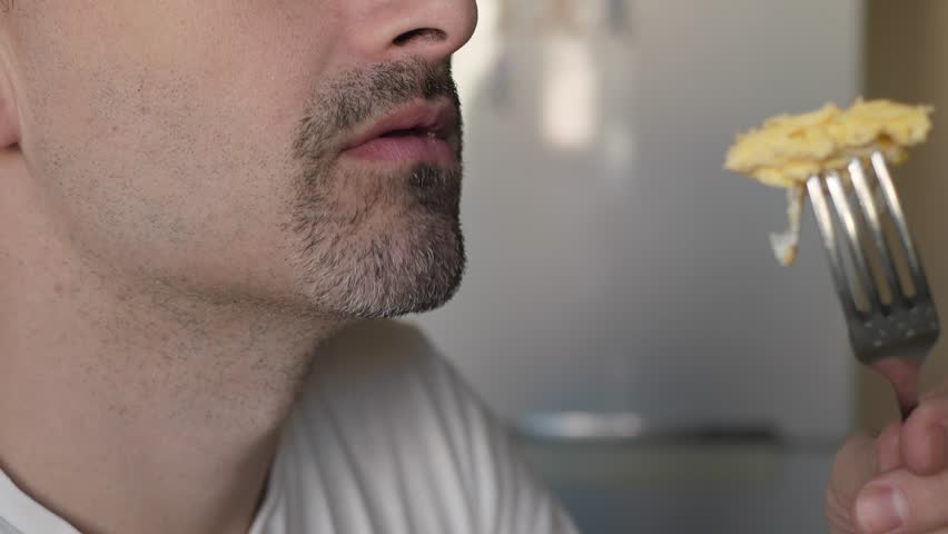 Man enjoys his delicious hot meal, skillfully using a fork for each bite, closeup. The joy of eating, reminding us of the simple pleasures in life that uplift our spirits and nourish our souls