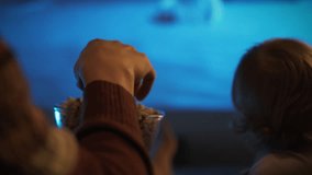Two hands reach for a bowl of popcorn in a warm and inviting living room. This moment captures the joy of sharing snacks while enjoying a movie together - Powered by Shutterstock - Get 15% off with code: PIKWIZARD15