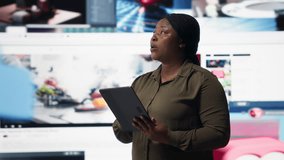 Close up of person using tablet, enjoying leisure time with online video content. Woman browsing social media app on device in front of digital backdrop filled with clips collage layout, camera B - Powered by Shutterstock - Get 15% off with code: PIKWIZARD15