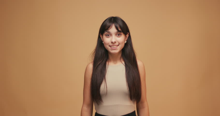 Portrait of joyful hispanic woman demonstrating copy space ad advert isolated over blue color background.