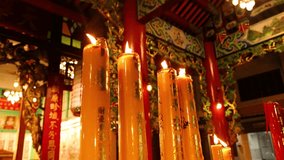 Tall candles burning in richly decorated Asian temple, warm ambient lighting, slight camera movement - Powered by Shutterstock - Get 15% off with code: PIKWIZARD15