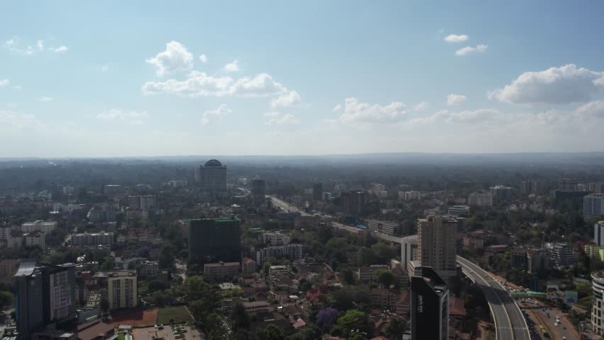 A stunning aerial drone footage of Westlands, Nairobi, Kenya, showcasing the bustling urban office spaces, modern residential areas, the Nairobi Expressway, and Waiyaki Way. Captured during the day.