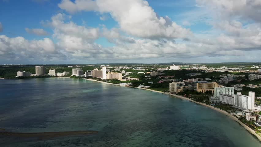 Panoramic Aerial time-lapse of picturesque Tumon Bay Coastline in Guam, USA with moving clouds during daytime.