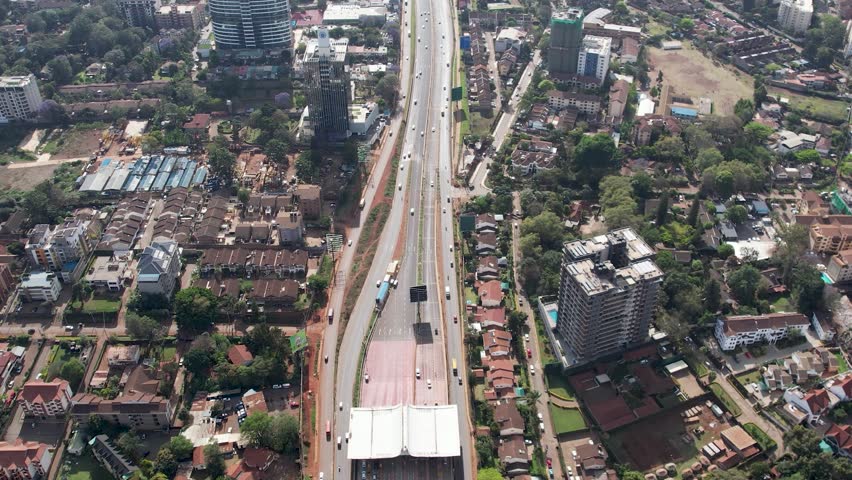 A stunning aerial drone footage of Westlands, Nairobi, Kenya, showcasing the bustling urban office spaces, modern residential areas, the Nairobi Expressway, and Waiyaki Way. Captured during the day.