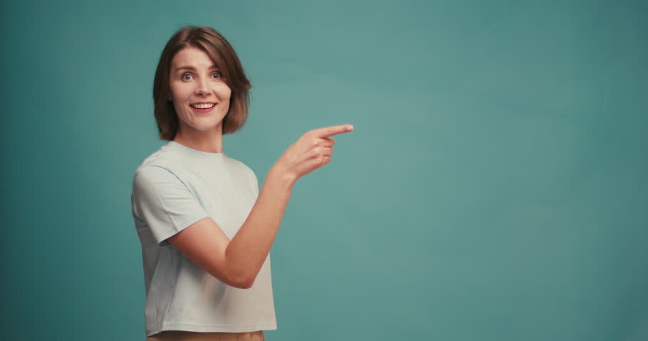 Portrait of joyful hispanic woman demonstrating copy space ad advert isolated over blue color background.